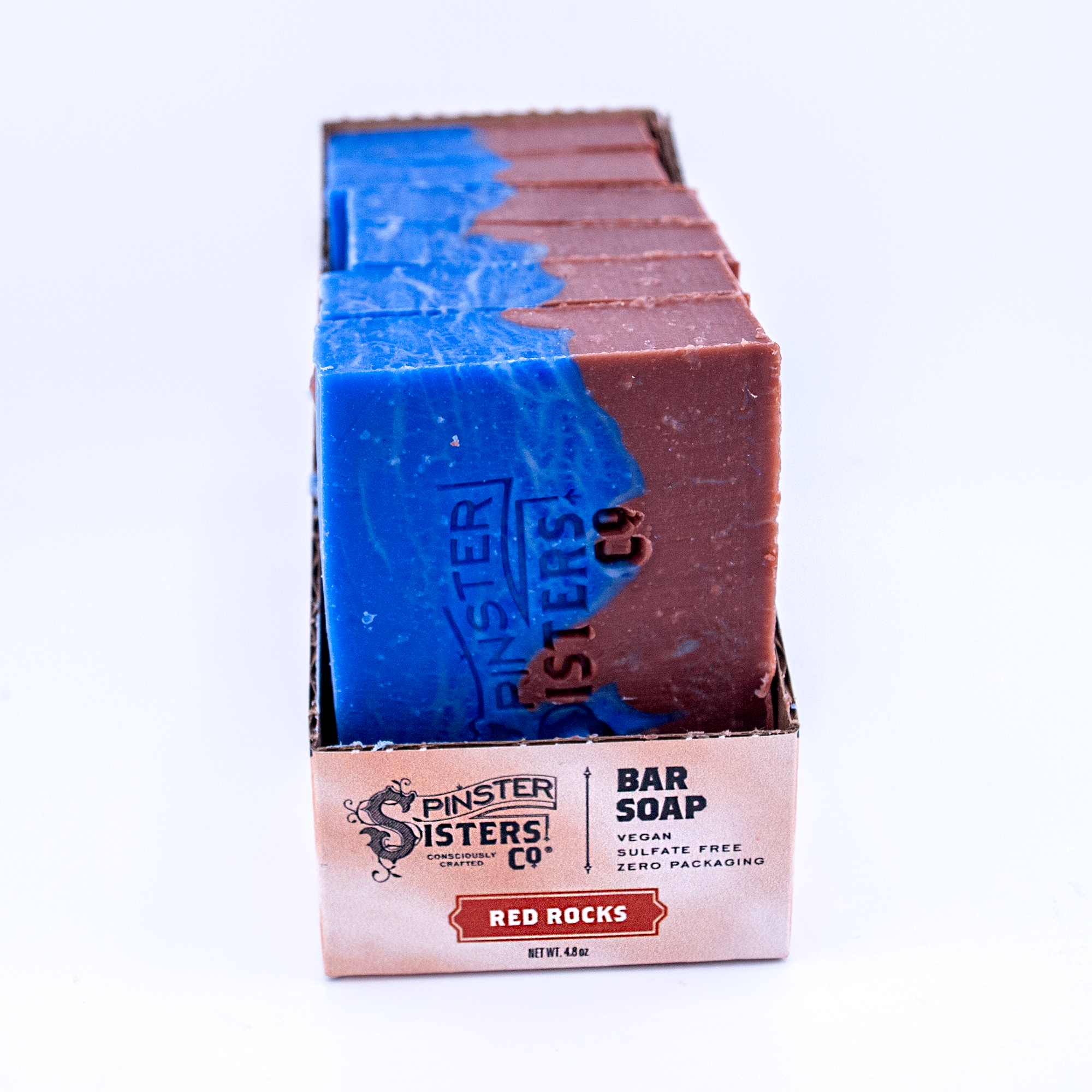 Case of Red Rocks Spinster Sisters Co. bar soaps with blue and red bars on a white background
