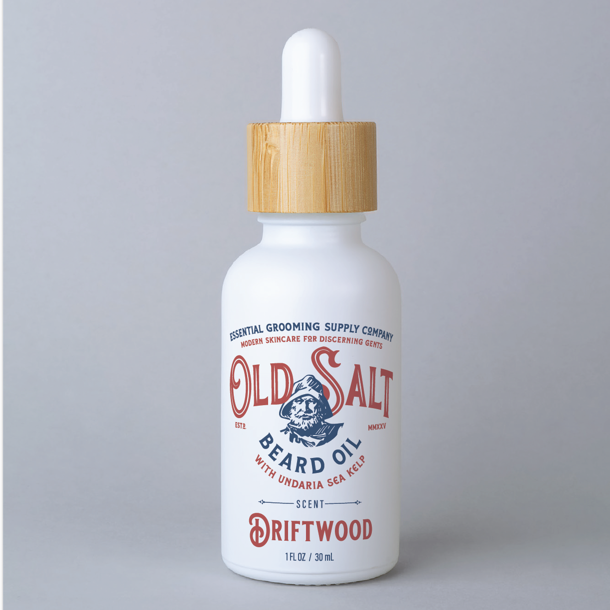 White bottle with wood dropper cap Label reads " Essential Grooming Spply Company, Modern Skincare for discerning gents. Old Salt Beard Oil with undaria sea kelp, Scent Driftwood" an image of a sailor in the center.