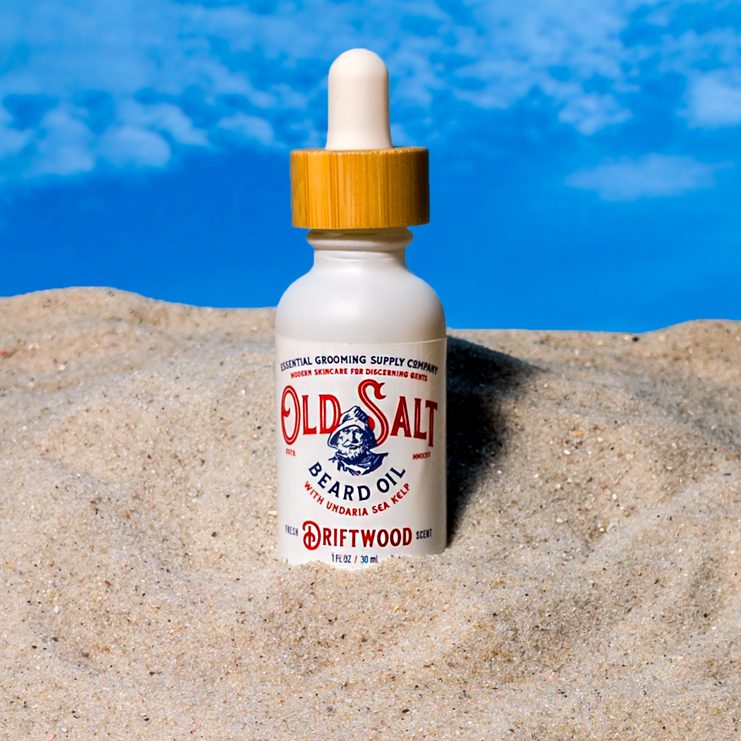 Bottle of Old Salt Beard Oil in Driftwood Scent on a Sandy beach