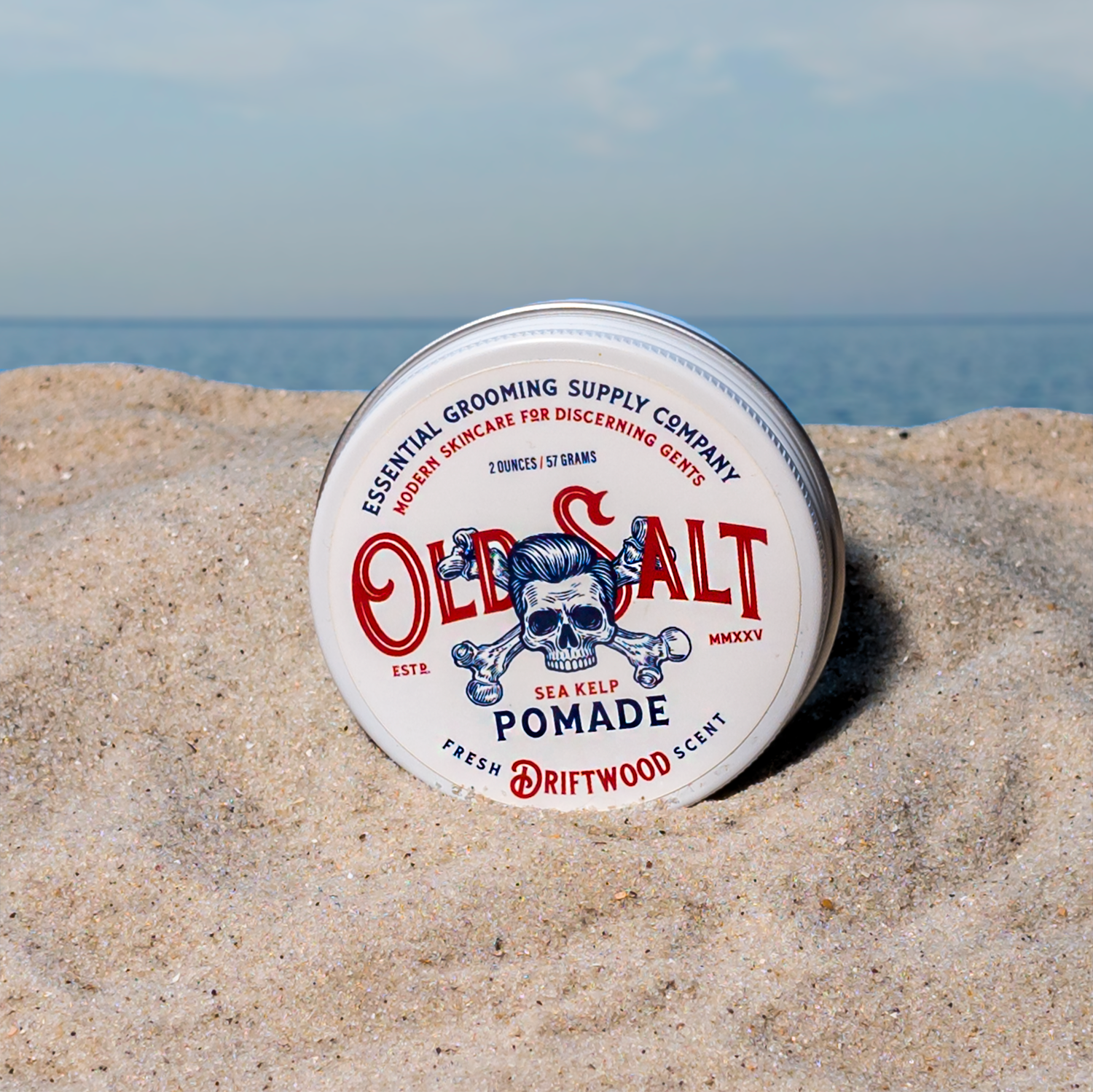 Tin of Old Salt Pomade in Driftwood Scent on a Sandy beach