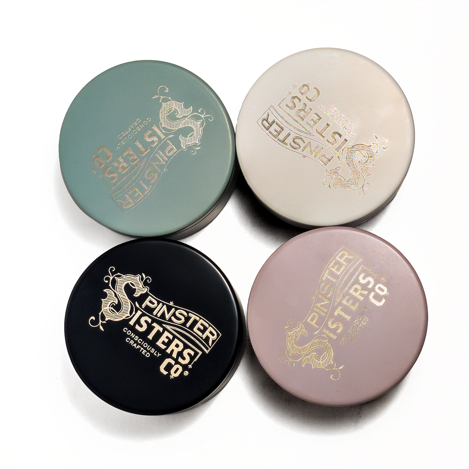 Four Colored Tins with 'Spinster sisters Co' etched on lids in Sage, Cream, Black and Blush on a white background
