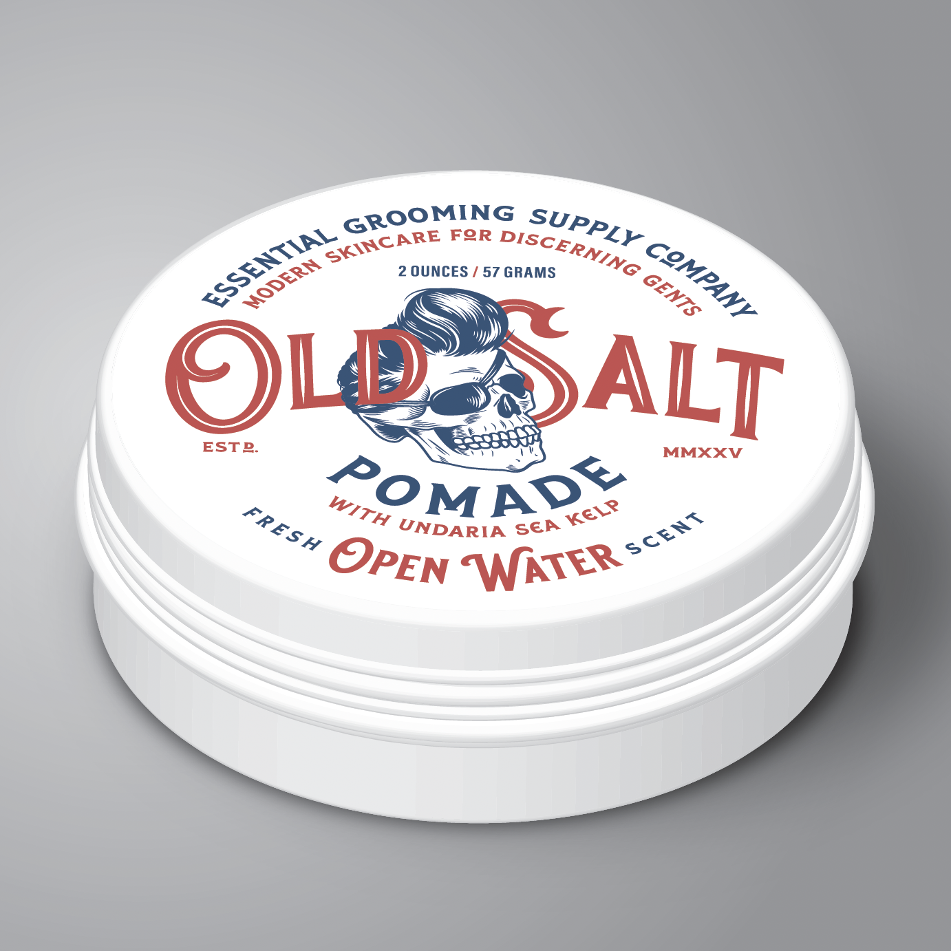White tin Label reads " Essential Grooming Supply Company, Modern Skincare for discerning gents. Old Salt Pomade with undaria sea kelp, Scent Open Water" an image of a skull with a pompadour and eye patch in the center