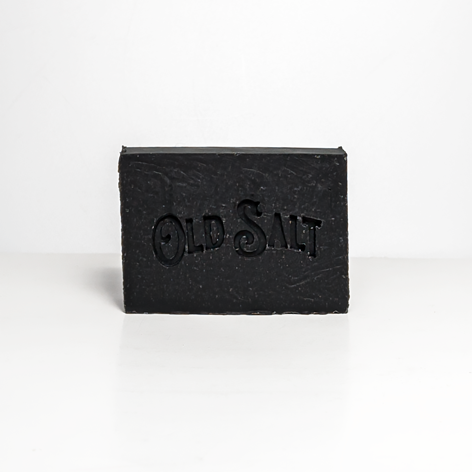 Black bar of Pine Tar & Lime soap with 'Old Salt' branding on a white background