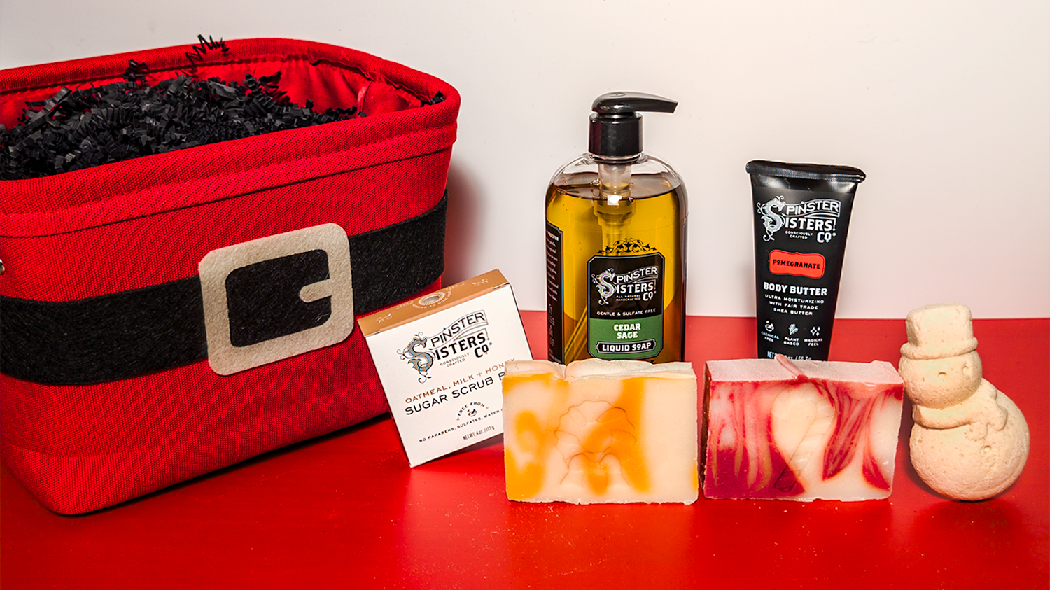 Santa Themed gift basket Featuring Spinster Sisters Products on Red and White Background