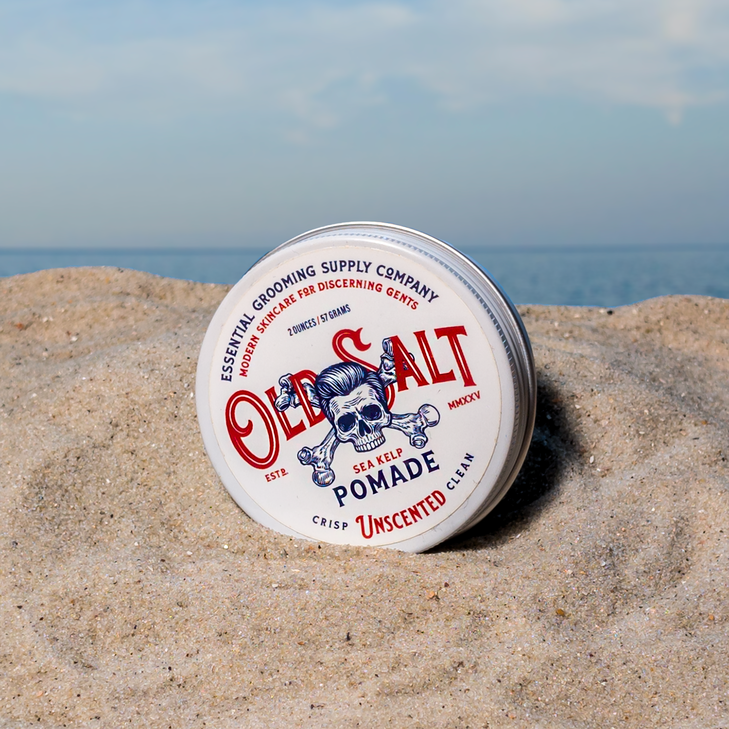 Tin of Old Salt Unscented Pomade on a Sandy beach