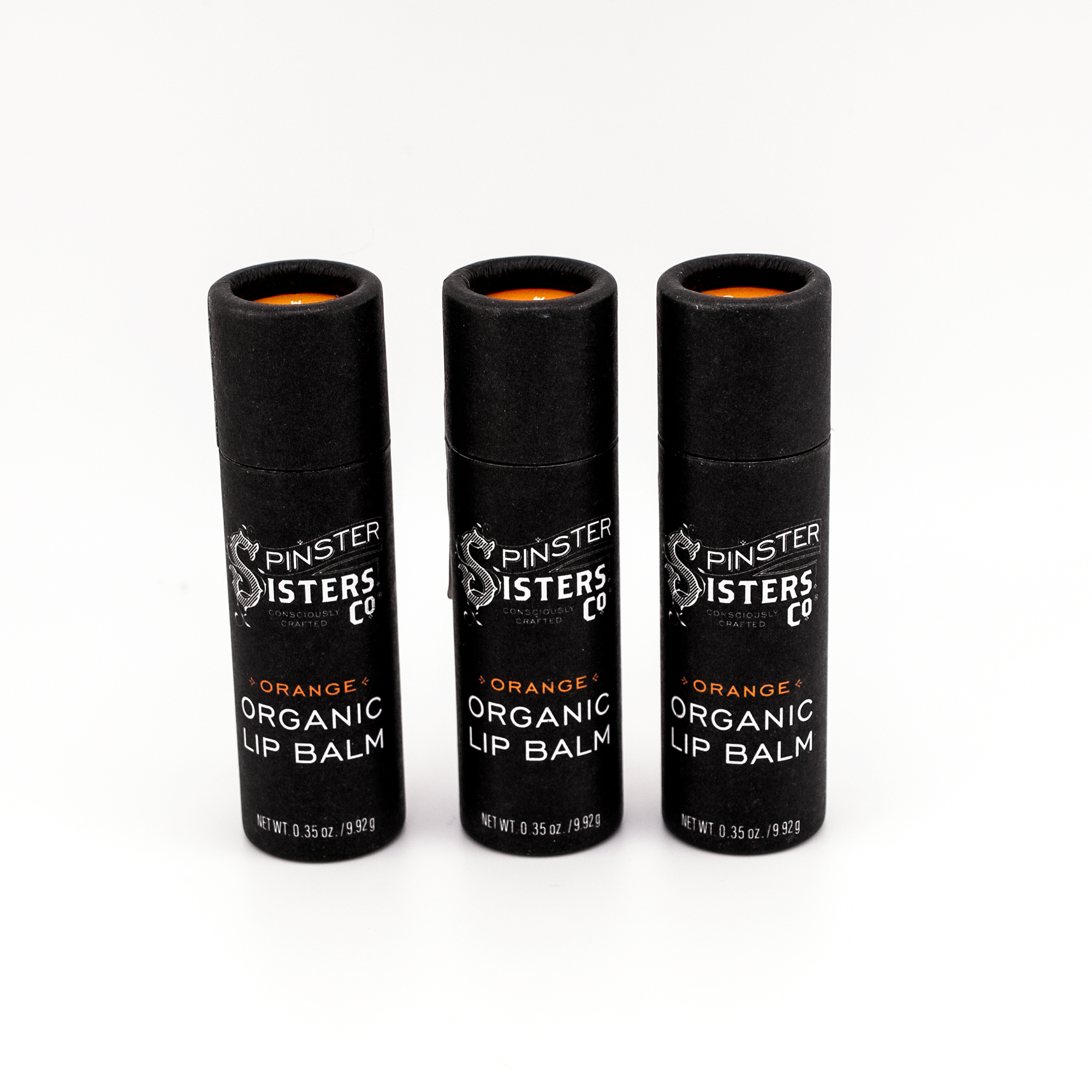 3 black paper tubes that say "Spinster Sisters Orange Organic Lip Balm" 
